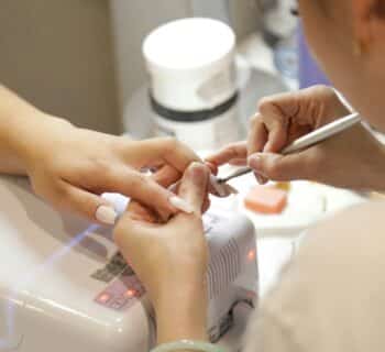 a woman getting her nails done at a nail salon